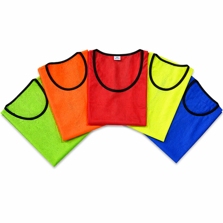 A stack of Justa Training Bibs in Red, Yellow, Pink, Orange, Green, and Blue showing the mesh texture